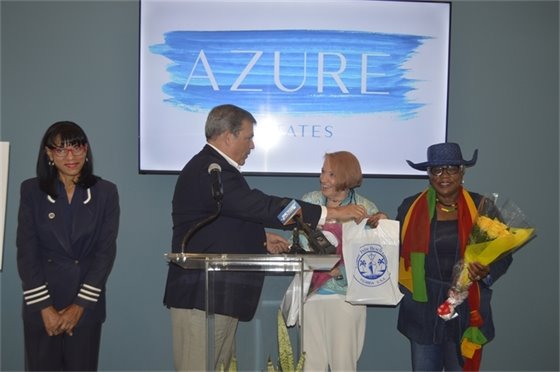 Manuel Almira handing gifts to Dr. Julie Botel and Mary Brabham 
